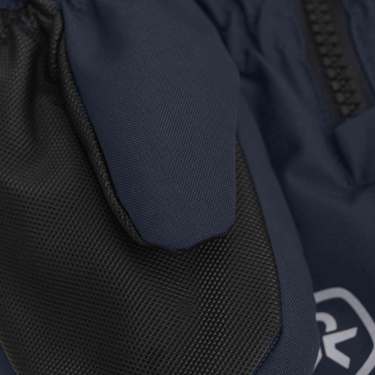 Nahaufnahme der Color Kids - Handschuhe Long W. Zipper in Dunkelblau, mit schwarzem Strukturstoff am Handgelenksbündchen und teilweiser Sicht auf einen schwarzen Reissverschluss. Die Handschuhe aus recyceltem Material haben sichtbare Nähte und ein undeutliches, in Weiss aufgedrucktes Logo.