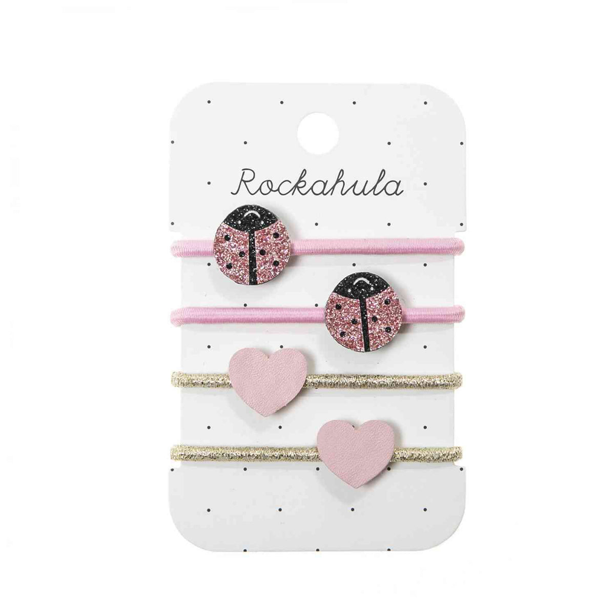 Ein Set Rockahula - Haargummis Lola Marienkäfer auf weißer Karte mit schwarzen Punkten. Es enthält zwei rosa Haargummis mit glitzernden Marienkäfer-Dekorationen und zwei goldene Haargummis mit Glitzer und rosa Herz-Dekorationen, perfekt für Naturfreunde.