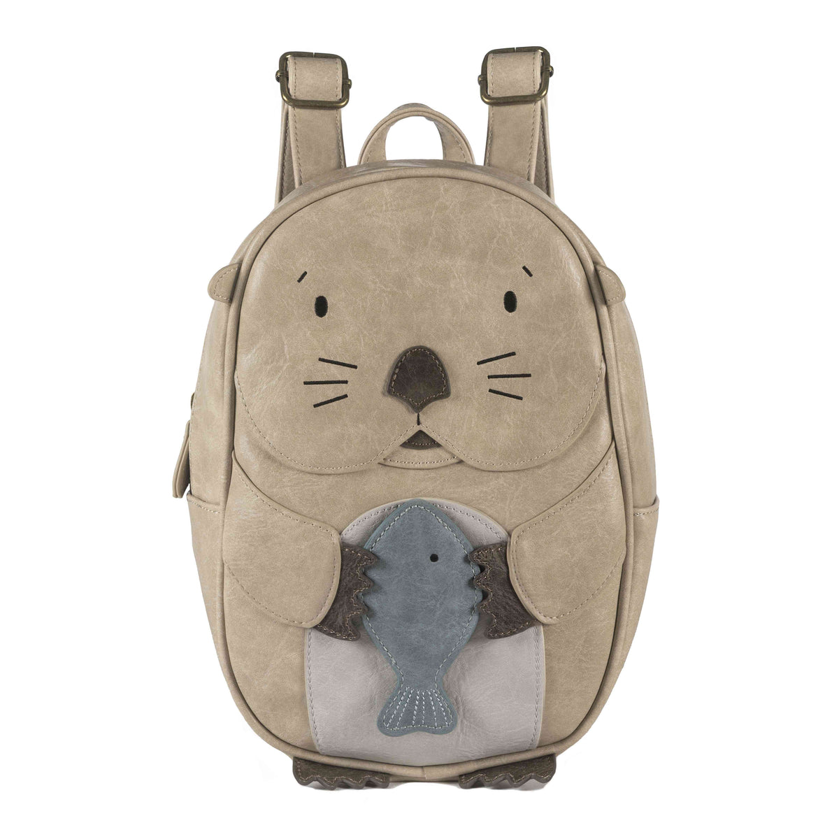 Ein hellbrauner Rucksack, der aussieht wie ein süßer Otter, der einen blauen Fisch hält. Der Little Who - Rucksack Otter Mathilda von Little Who hat ein Ottergesicht mit kleinen Ohren, Augen, einer Nase und Schnurrhaaren und hat verstellbare Schultergurte an der Oberseite. Ideal für jedes Kinderartikelgeschäft, das bezaubernde und einzigartige Artikel für Kinder sucht.