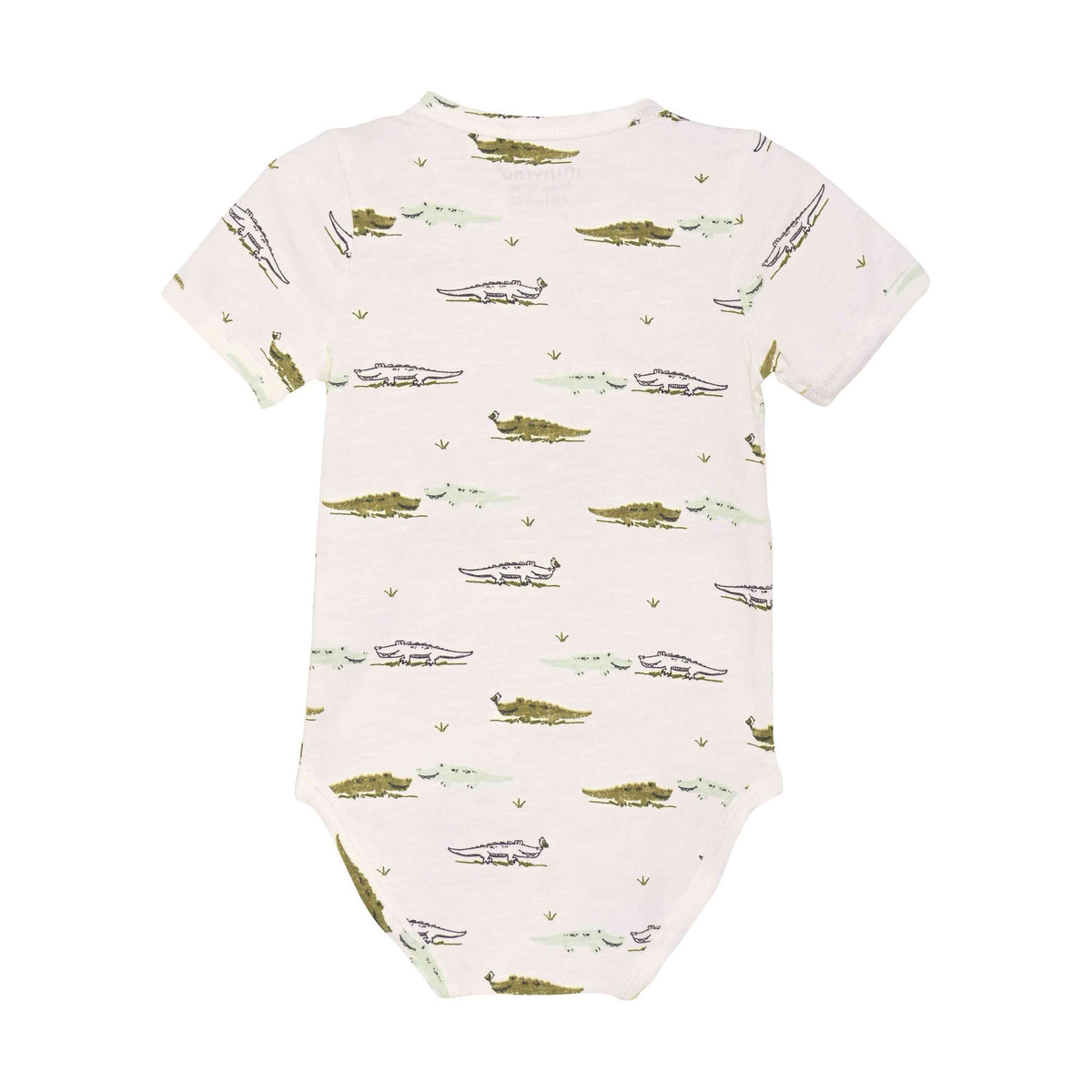 Ein weißer Minymo - Body kurzarm mit Allover-Print-Strampler mit einem Muster aus grünen Krokodilen in verschiedenen Positionen. Die Krokodile sind gleichmäßig über den Bambusstoff verteilt und sorgen für einen Hauch von Minimalismus. Auf dem Bild ist die Rückseite des Stramplers zu sehen.