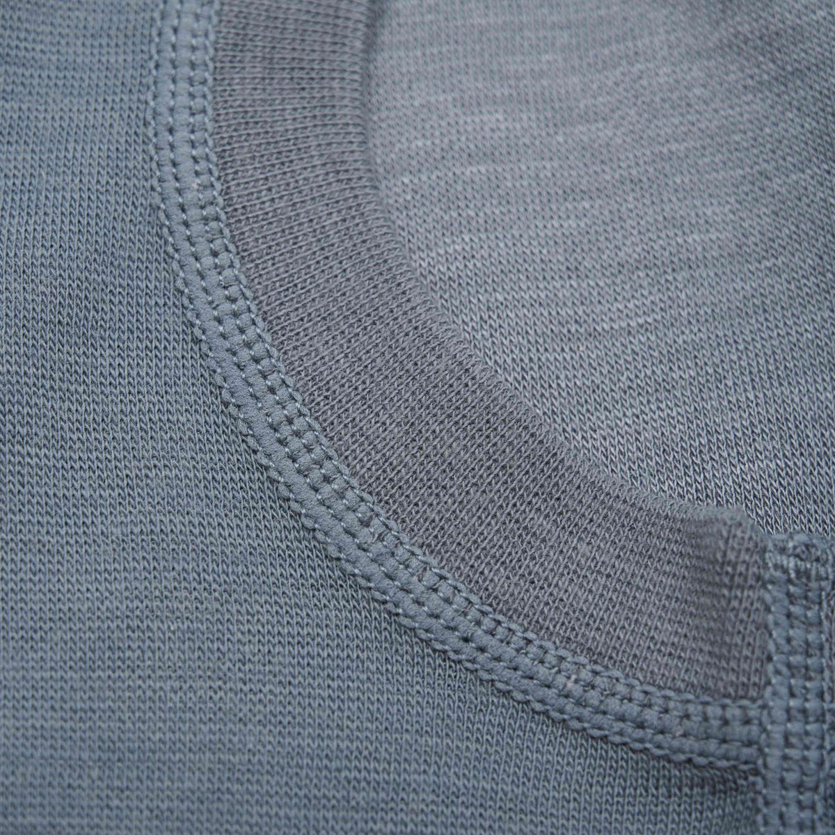 Nahaufnahme des Halsausschnitts der CeLaVi-Sturmhaube, die die Textur und die Nähte zeigt. Das Bild hebt den glatten, fein gewebten Stoff aus 100 % Merinowolle und die sauber verarbeitete Kragennaht hervor. Diese Sturmhaube ist nach OEKO-TEX® STANDARD 100 zertifiziert, was für zusätzliche Sicherheit sorgt.