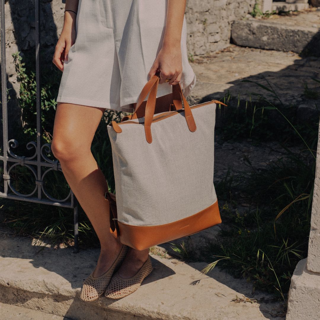 Rucksack aus Canvas in Caramel in der Hand tragend